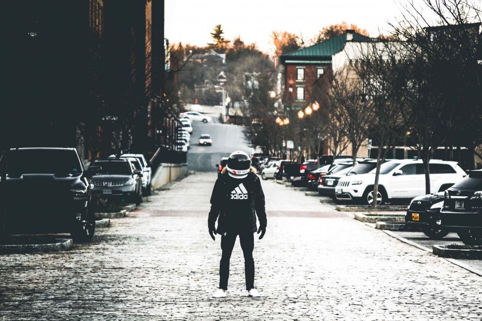 Free Image of Moody street with a person in astronaut helmet 