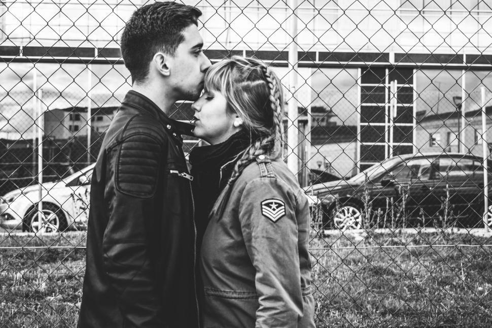 Free Image of Couple embracing by the fence black and white 