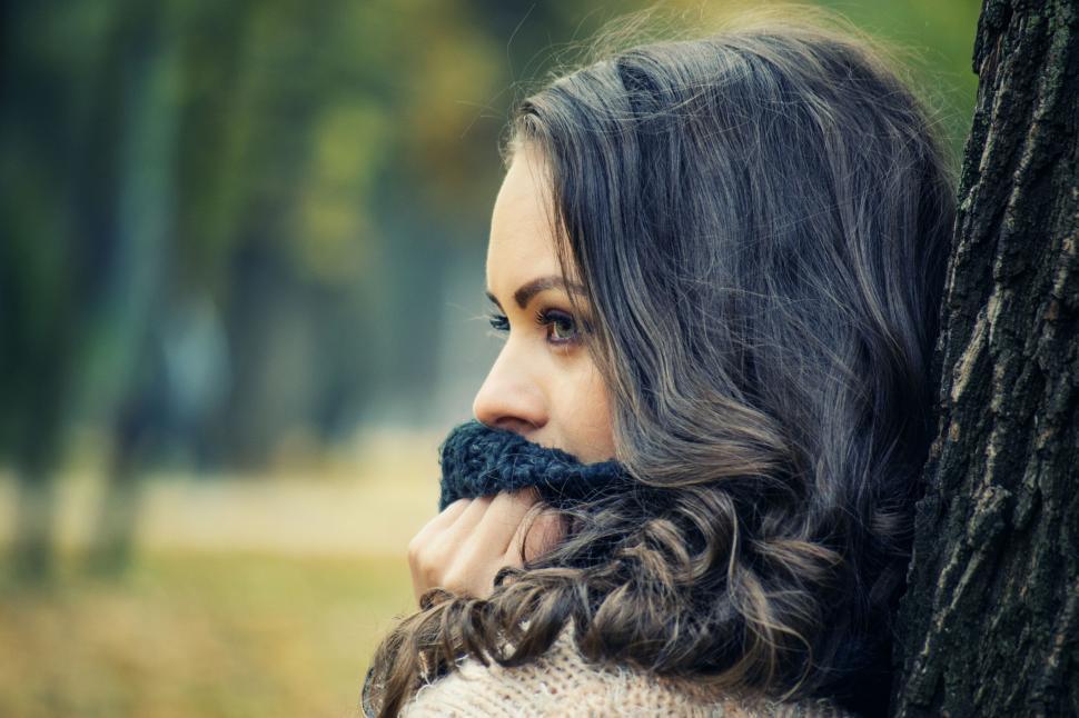 Free Image of Woman leaning against tree in autumn park 