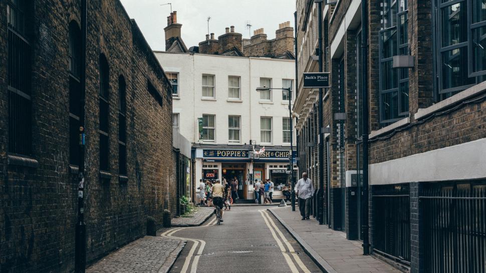 Free Image of Quiet alleyway leading to a bustling street 