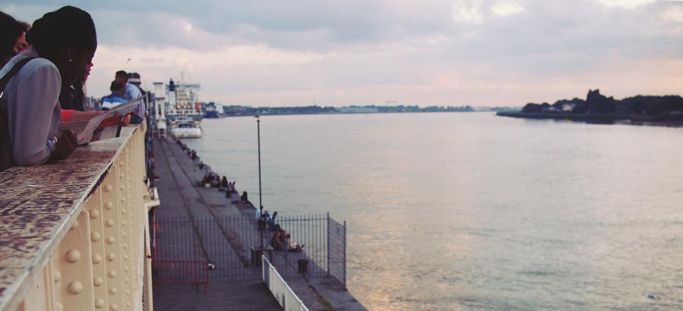 Free Image of Tranquil riverside with leisurely individuals 