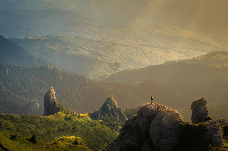 Free Image of Person on a cliff admiring a sunset 