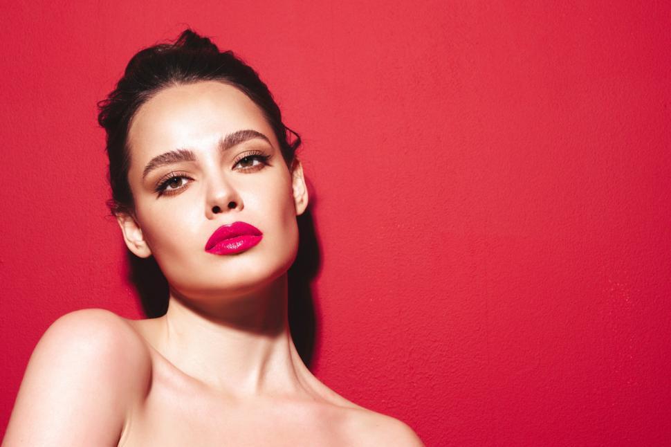 Free Image of A woman with bright pink lipstick 