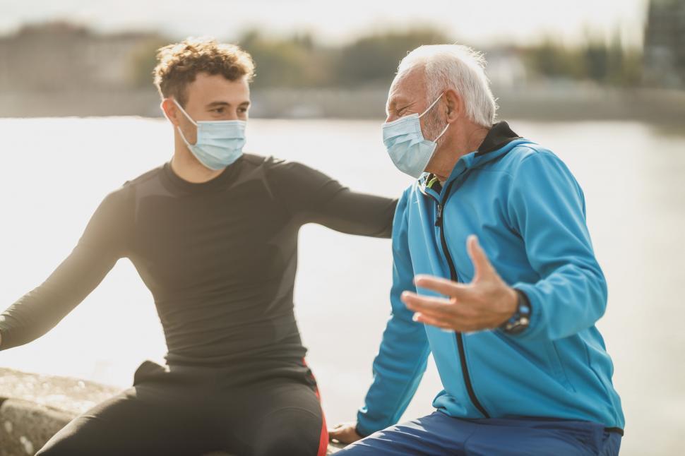 Free Image of Men talking while wearing masks 