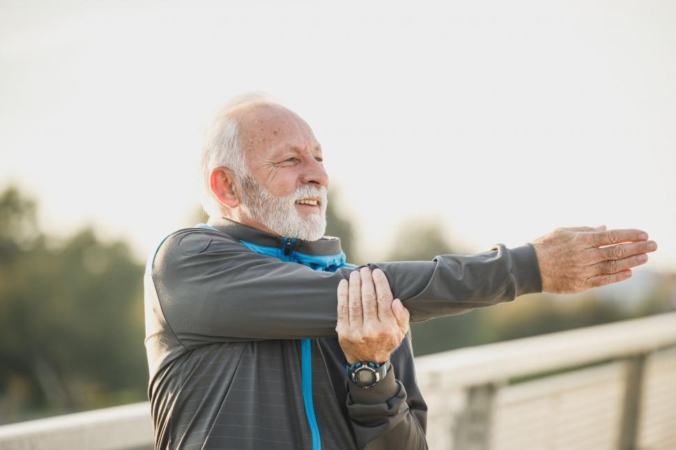 Free Image of Elderly man stretching his arms outdoor 