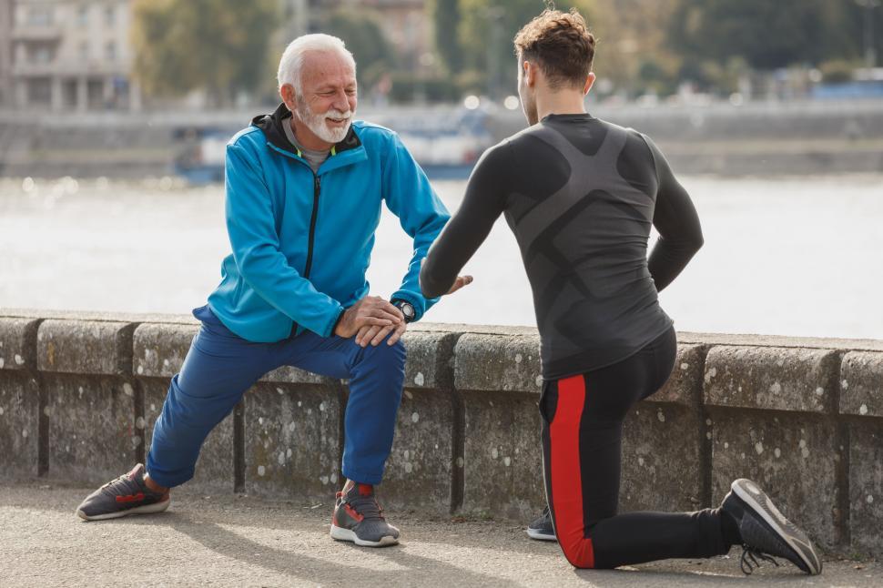 Free Image of Two men stretching and resting after a run 