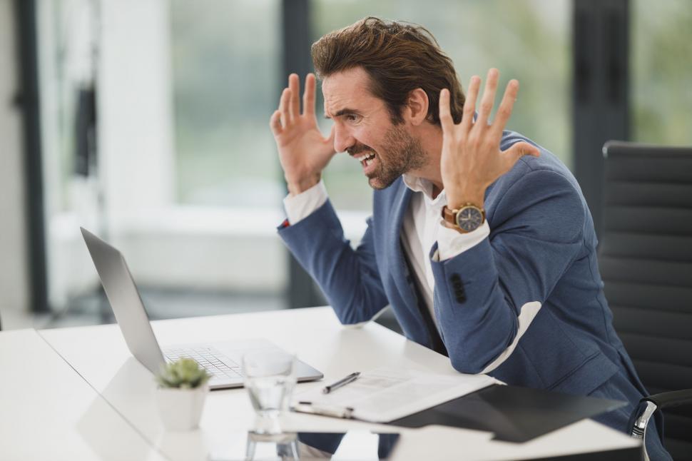 Free Image of Stressed businessman with laptop in office 