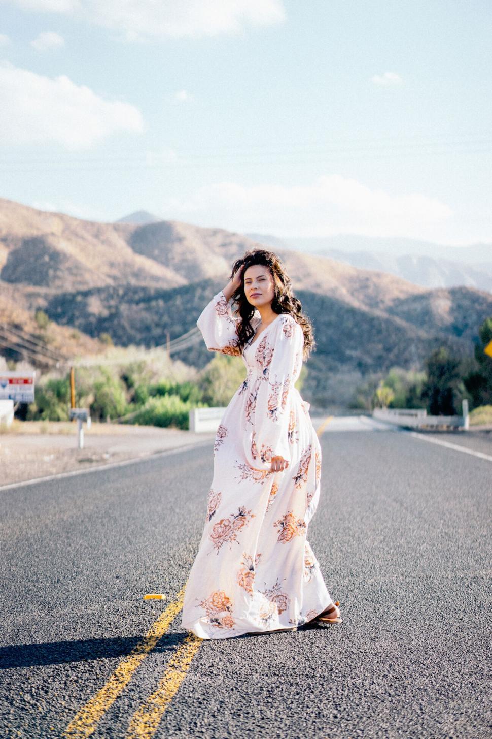 Free Image of Woman standing on scenic road in daylight 