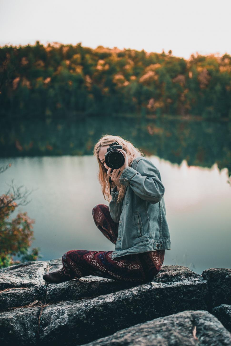 Free Image of Photographer kneeling on rocky terrain 