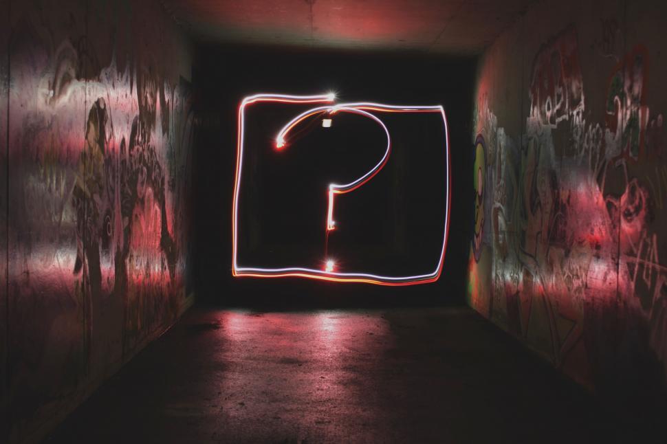Free Image of Neon Light Question Mark in a Dark Graffiti Tunnel 