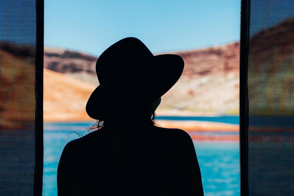 Free Image of Silhouette of woman in hat against landscape 