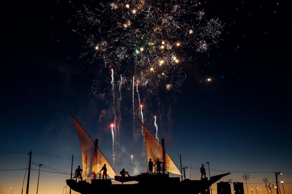 Free Image of Fireworks display above silhouette figures 