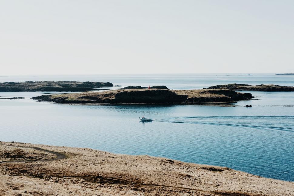 Free Image of Scenic view of islands in calm sea with boat 