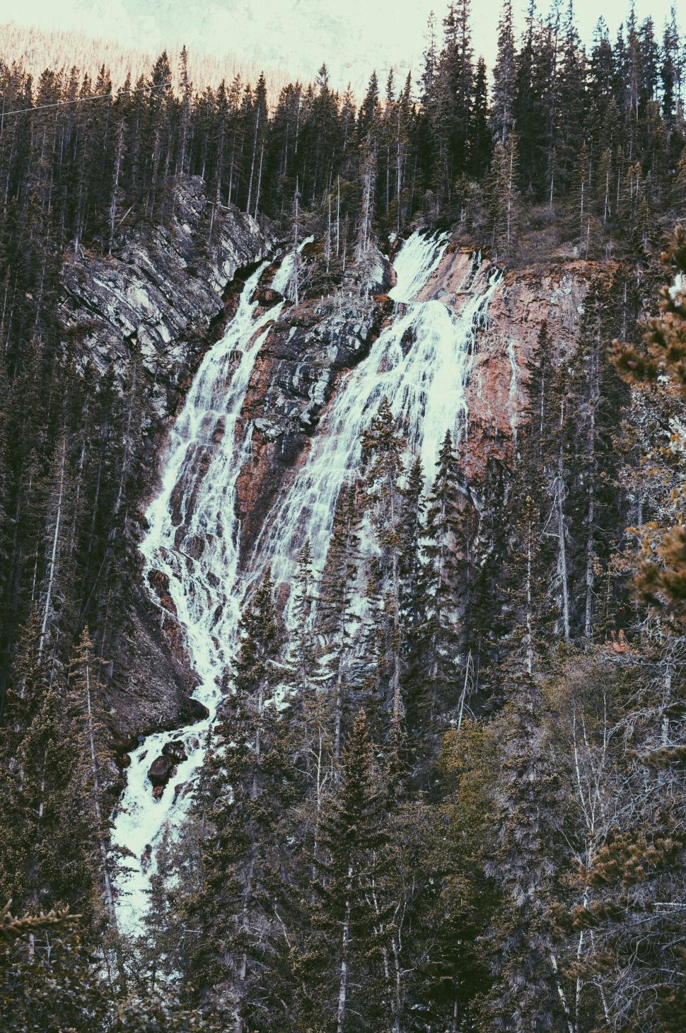 Free Image of Majestic waterfall cascading through forest 