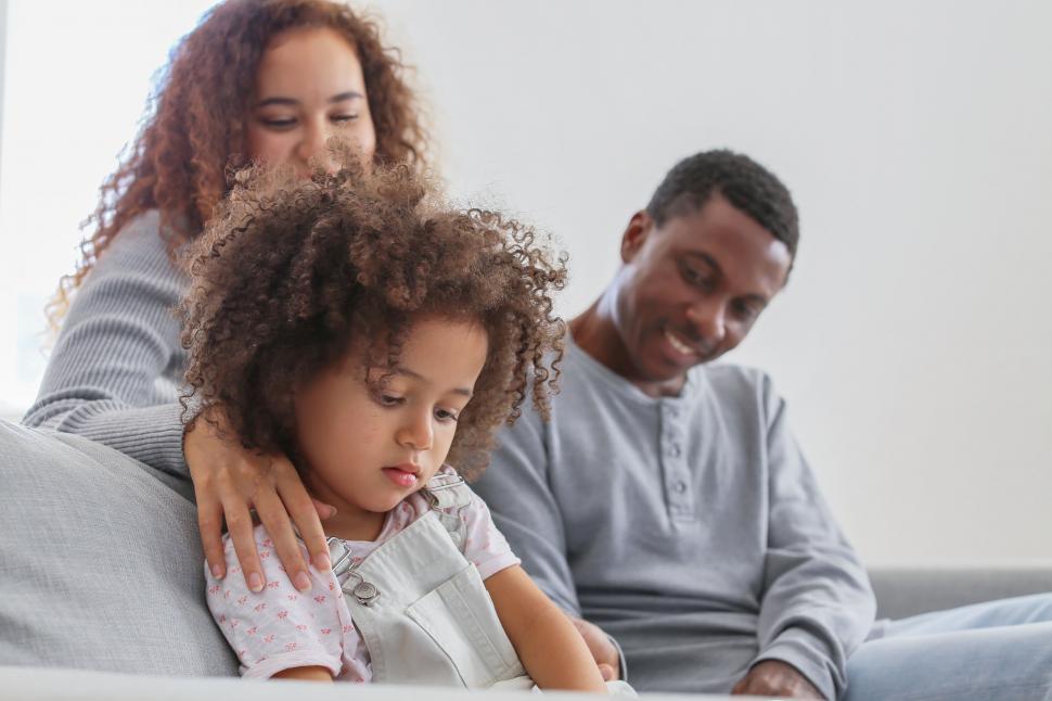 Free Image of Family sitting on couch with loving embrace 