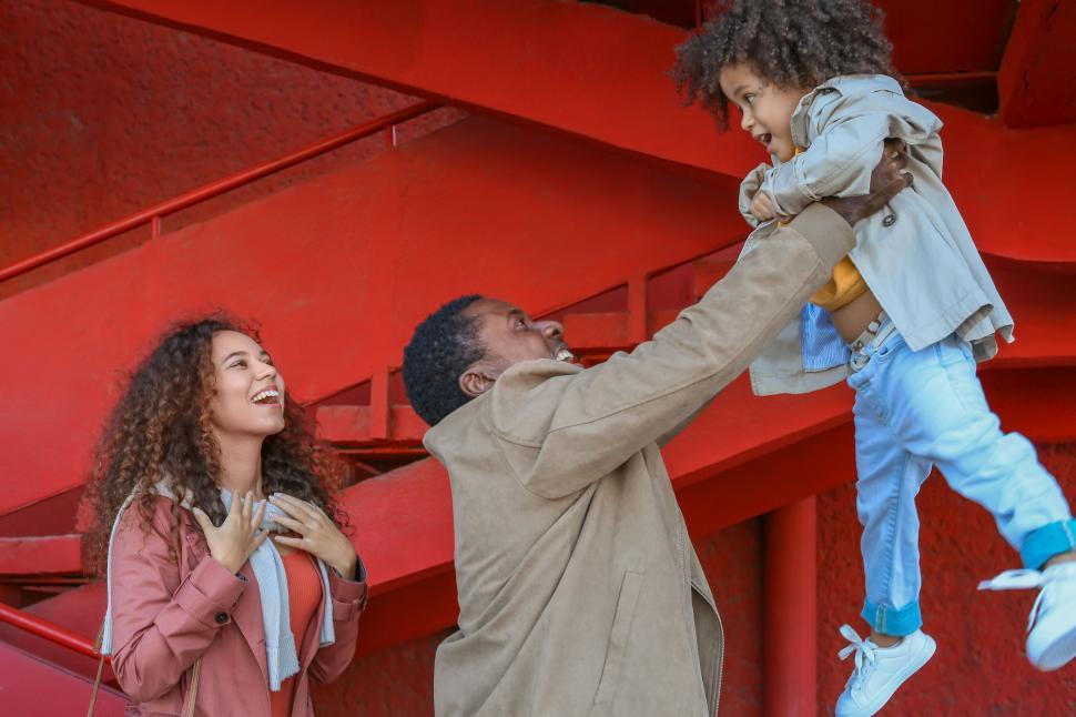 Free Stock Photo of Child being lifted by father near red structure ...