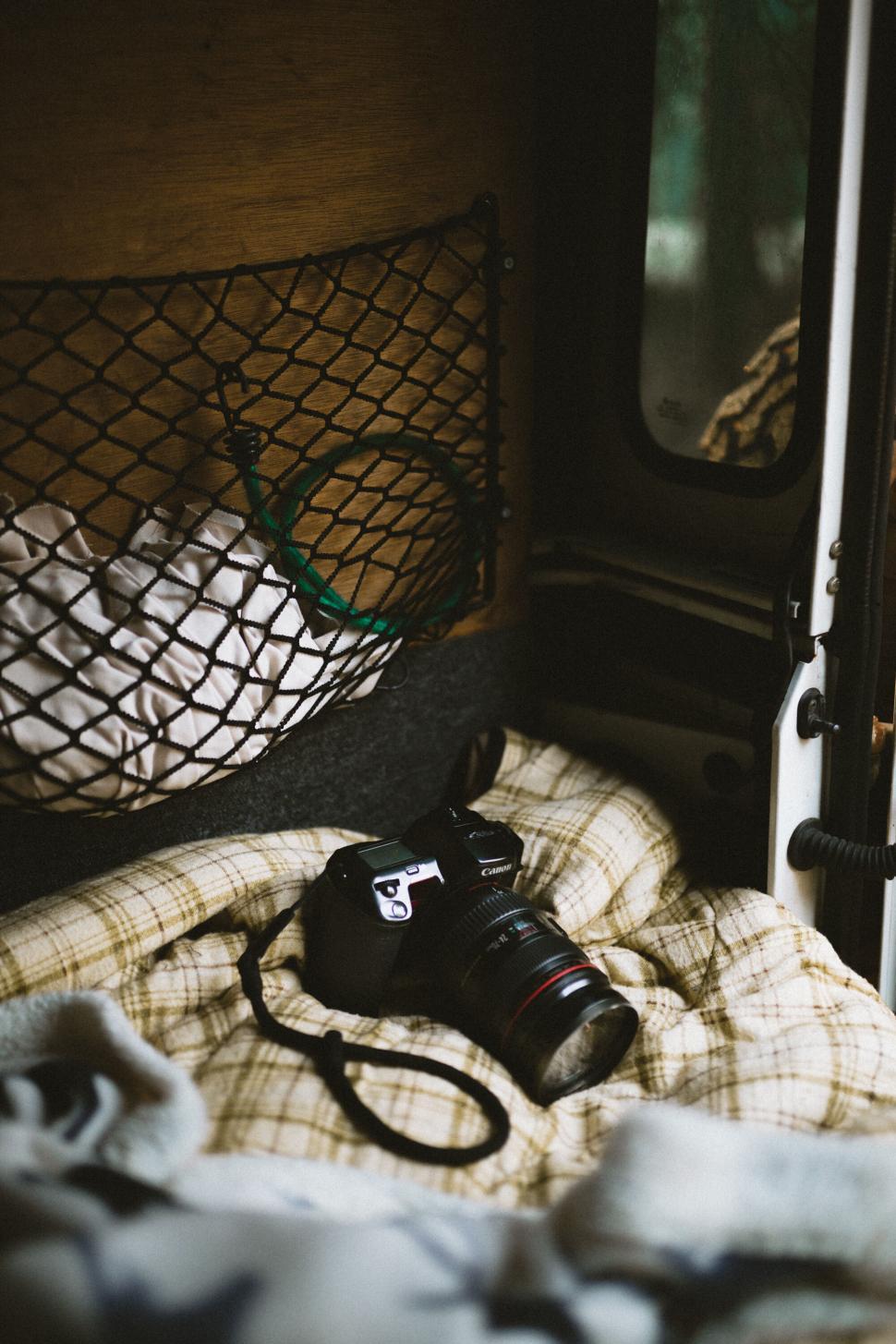Free Image of DSLR camera resting on plaid blanket 