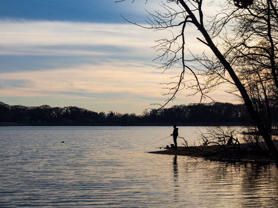 Serene Silhouette of a Fisherman Catching a Fish