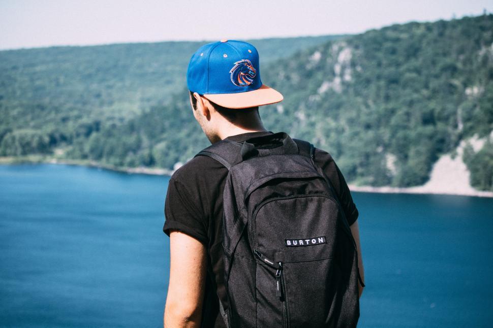 Free Image of Man overlooking a serene lake landscape 