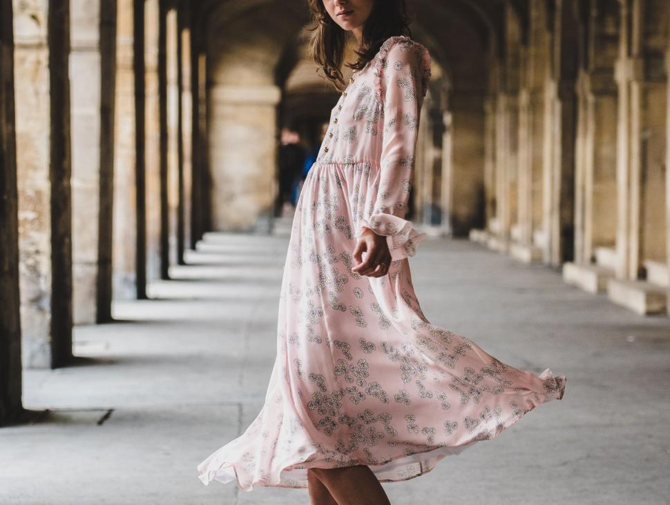 Free Image of Woman in a flowing dress strolling in an arcade 