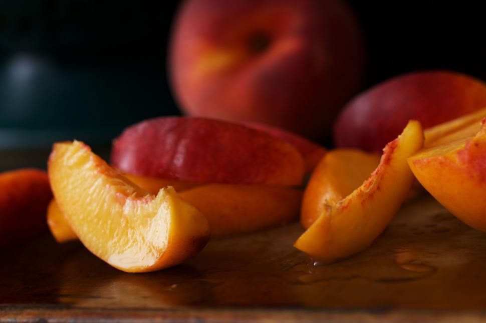 Free Image of Fresh juicy peaches sliced on wooden board 