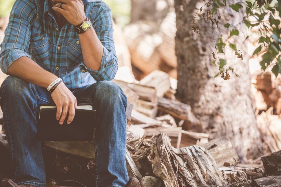 Free Image of Man sitting outdoors reading on a digital tablet 