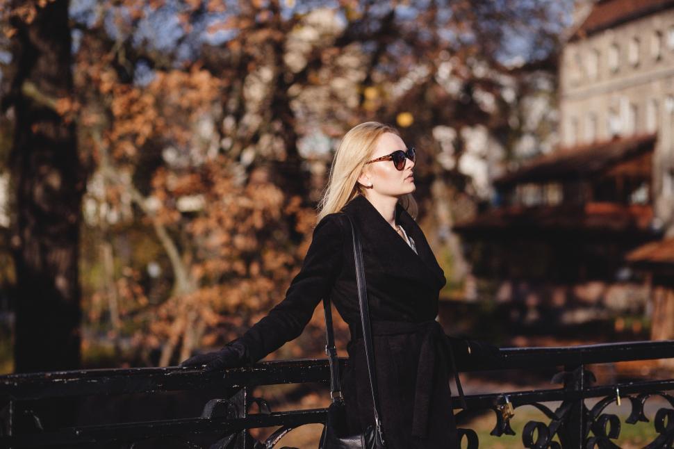Free Image of Woman leaning on a bridge in autumn season 