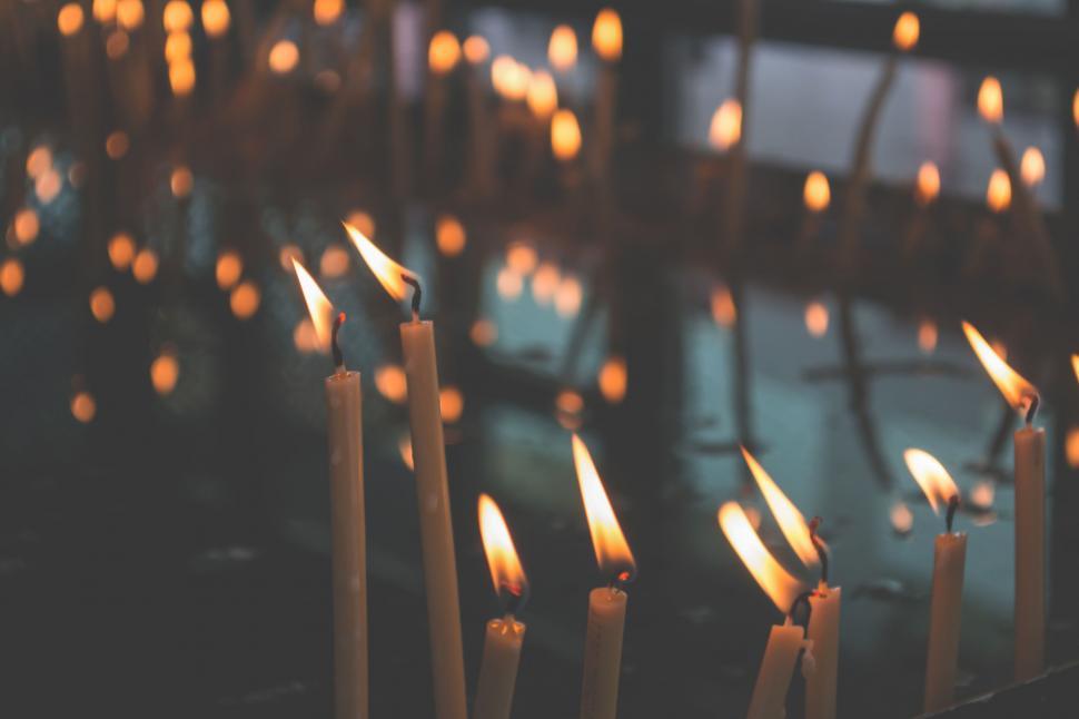 Free Image of Candle flames glowing in tranquil darkness 