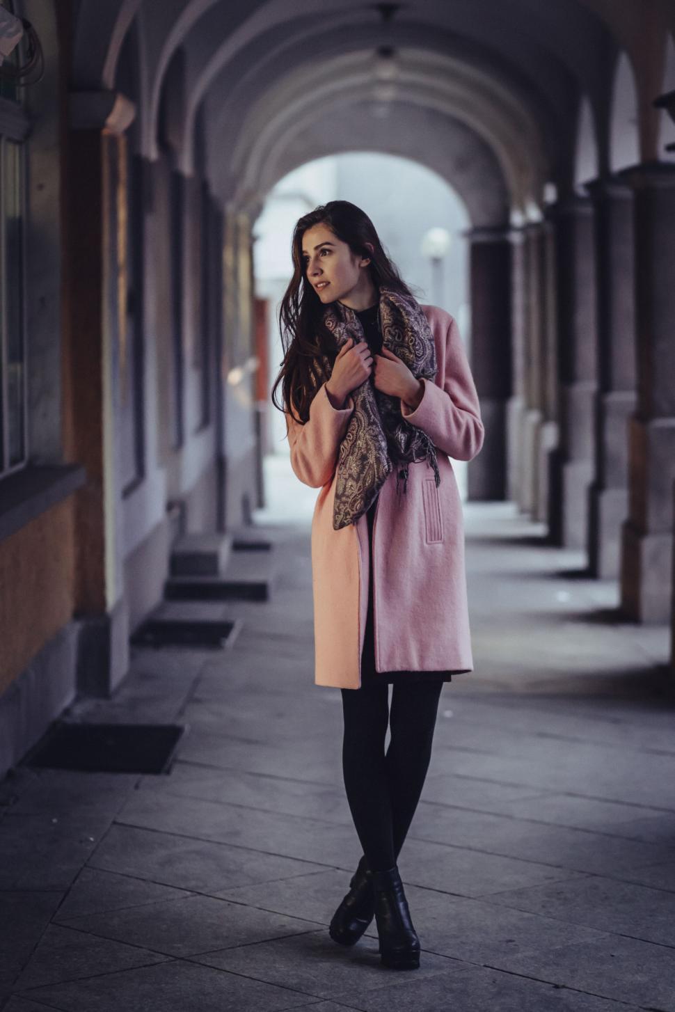 Free Image of Woman walking in an arched corridor 
