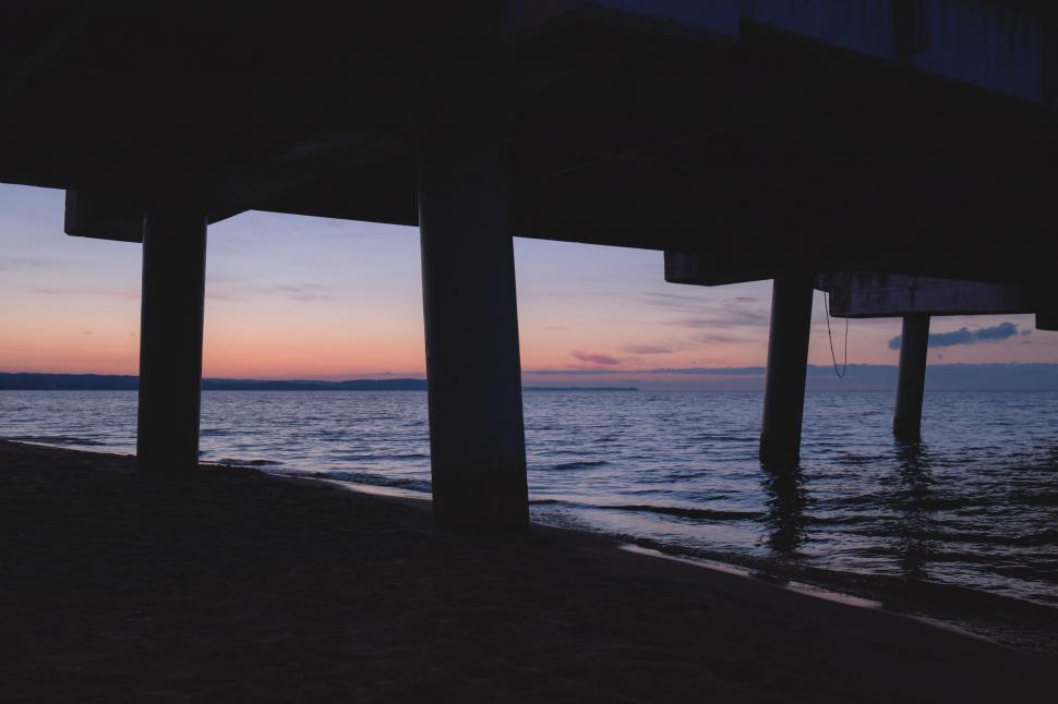 Free Image of Serene view under the pier at sunset 