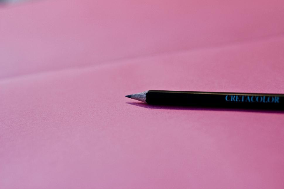 Free Image of Black pencil on a pink surface 