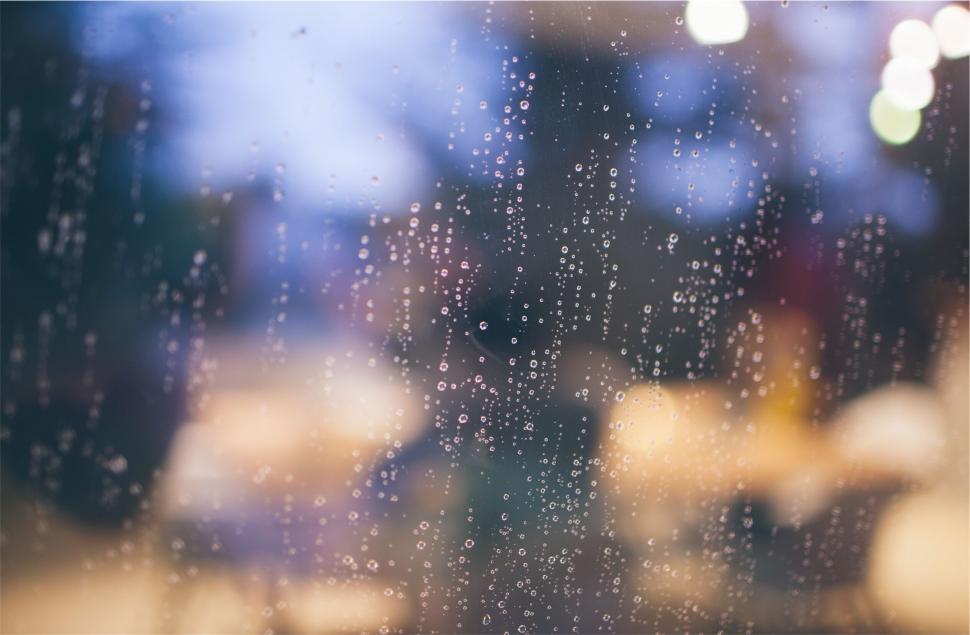 Free Image of Raindrops on a window with blurred background 
