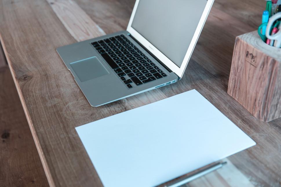Free Image of Laptop on wooden desk with blank paper 