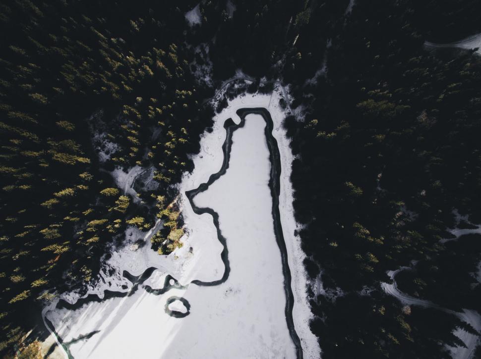 Free Image of Aerial view of frozen river among trees 