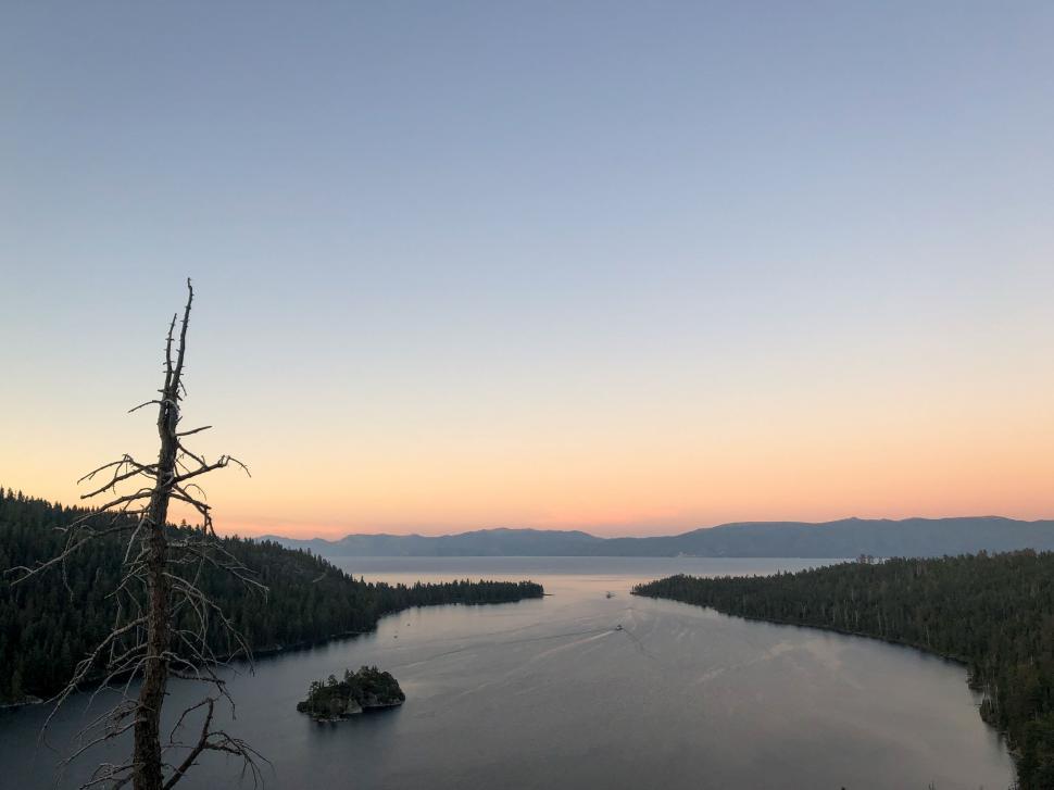 Free Image of Dusk over a calm lake with silhouetted trees 