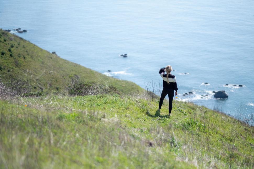 Free Image of Woman overlooking cliff at the ocean 