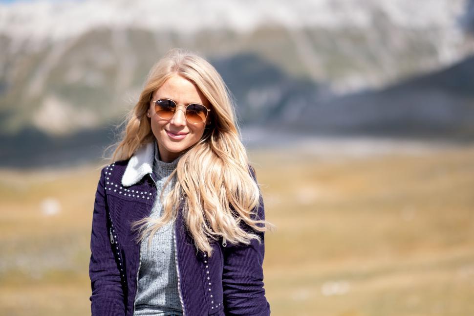 Free Image of Blonde woman with sunglasses in mountain area 