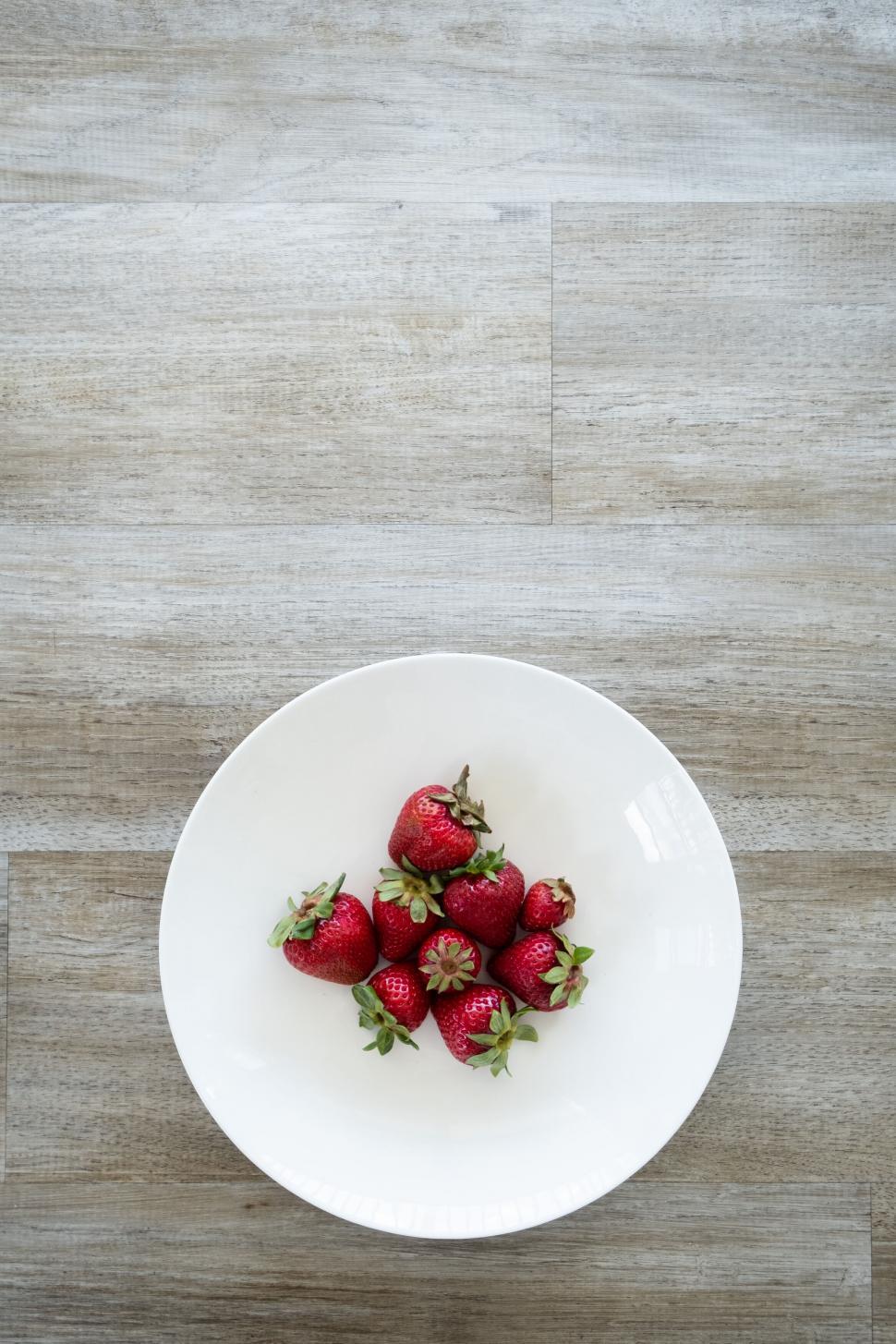 Free Image of Plate of Strawberries on Wooden Floor 