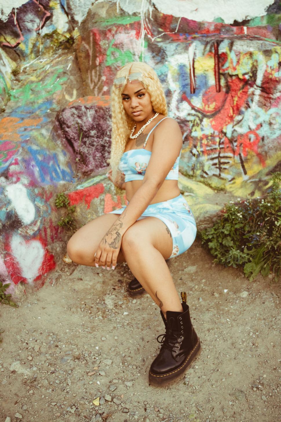 Free Image of Stylish young woman against graffiti wall 
