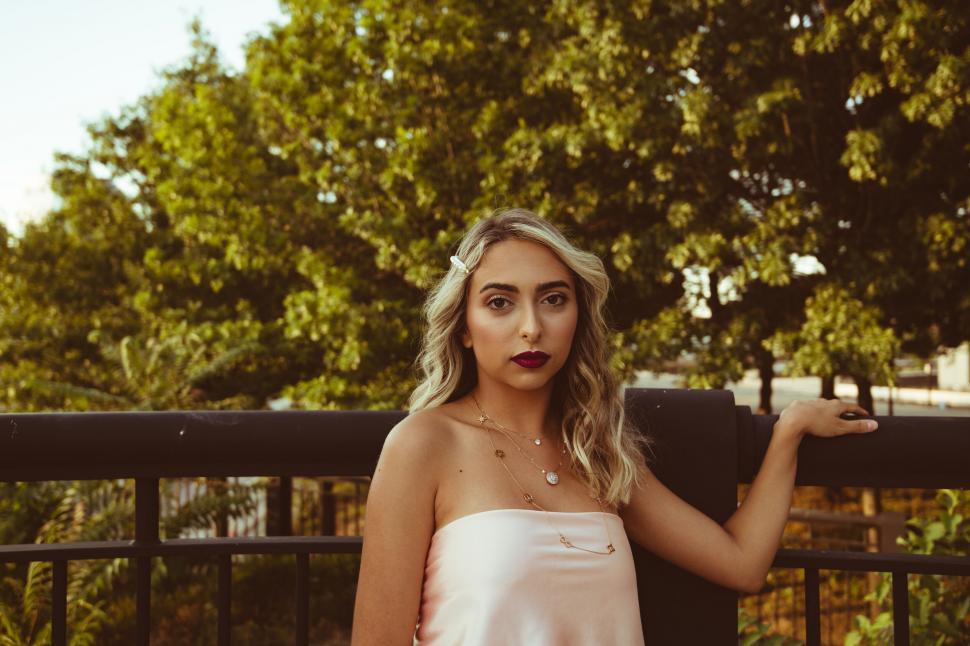 Free Image of Elegant woman leaning on balcony rail 