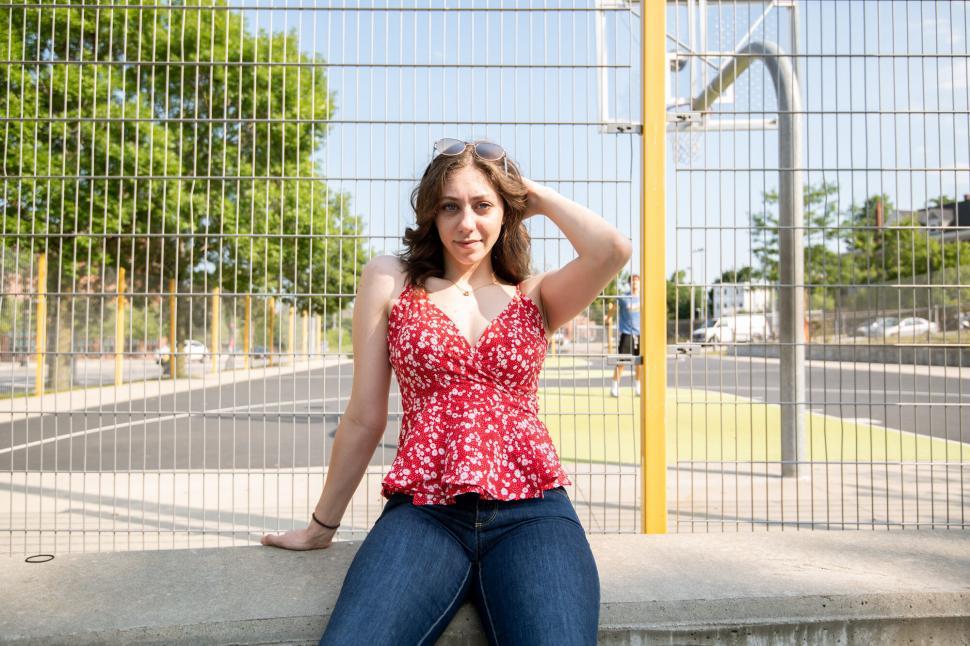 Free Image of Woman in Red Floral Top Sitting 
