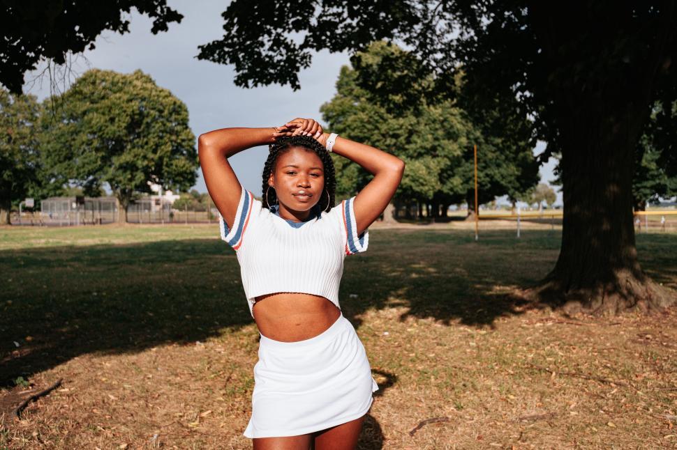 Free Image of Sporty girl stretching under a tree 