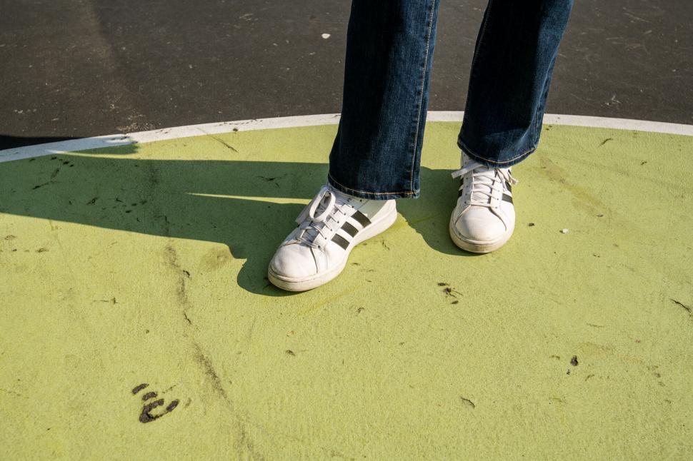 Free Image of Closeup of feet in sneakers on green court 