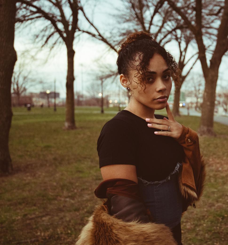 Free Image of Fashionable woman with a park backdrop 