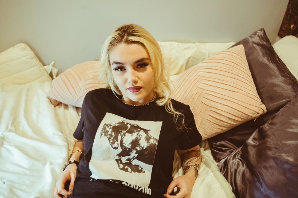 Free Image of Casual woman lying on messy bed 