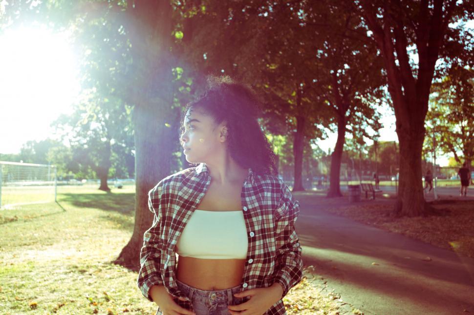 Free Image of Woman in sunlight in a city park 