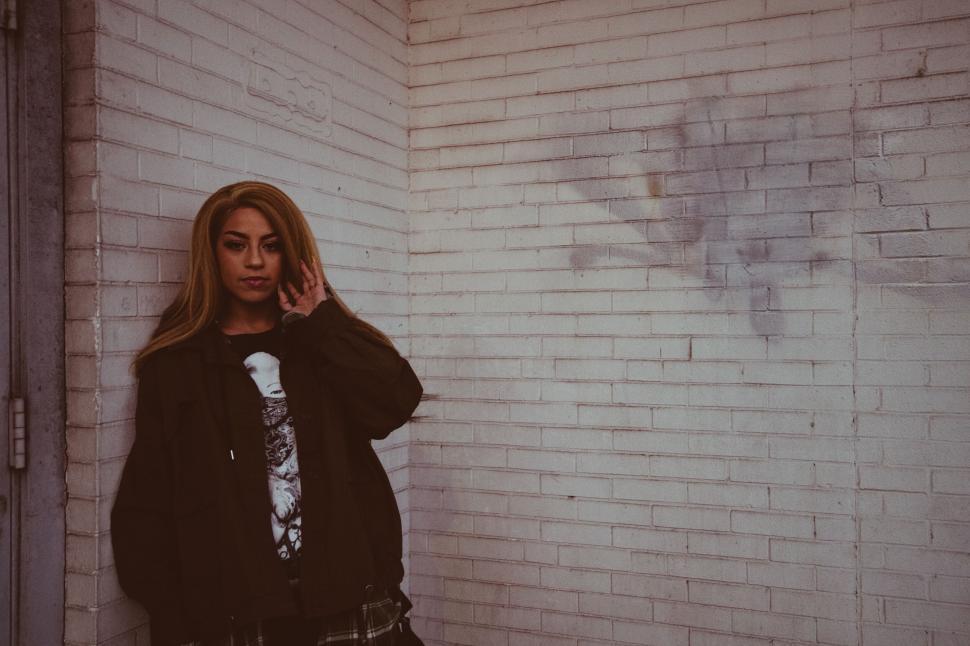 Free Image of Young woman in urban setting with white wall 