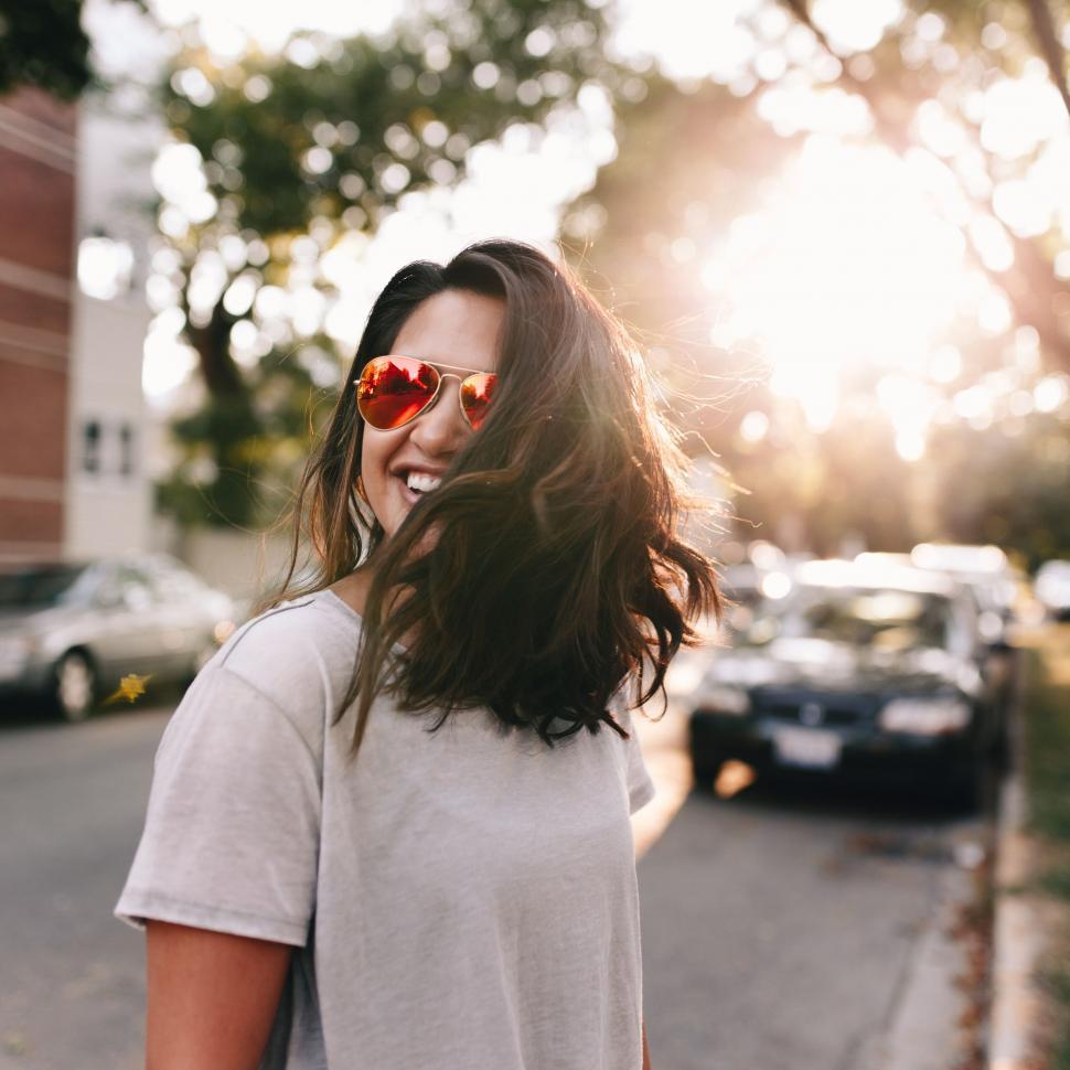 Free Image of Woman in sunlight on urban street 