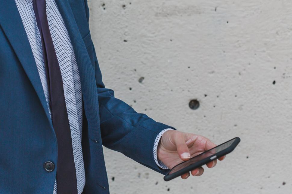 Free Image of Businessman checking phone with a stylish suit 