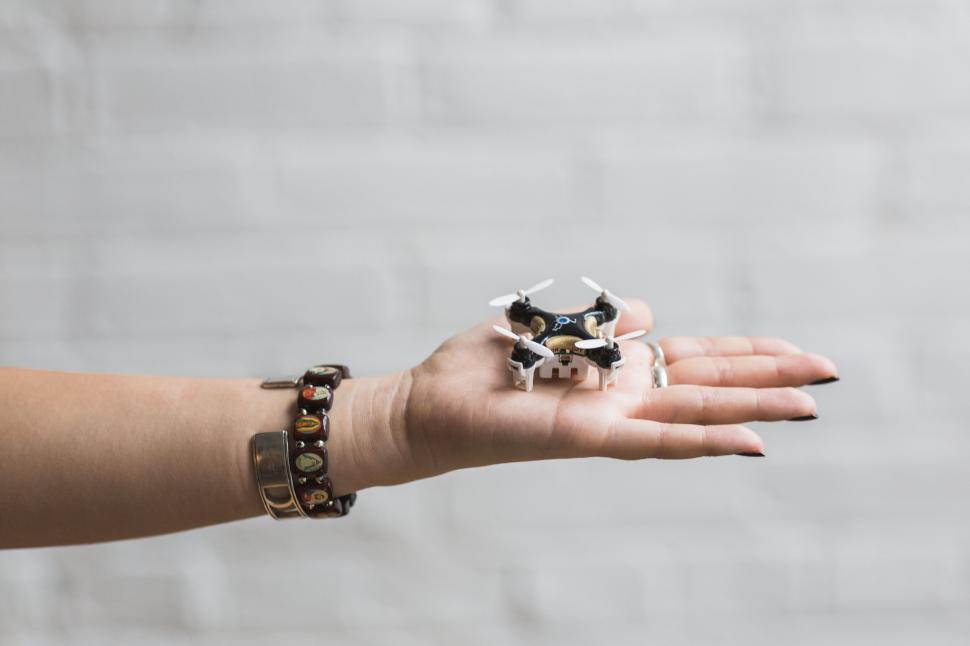 Free Image of Palm holding a mini drone on white background 